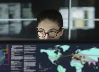 Woman looking at a computer screen with map of the world