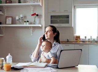 Mother working whilst holding baby