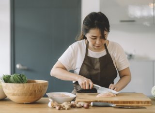 Getty - woman chopping meat