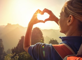 Sustainable tourism image with woman making heart-shape with hands