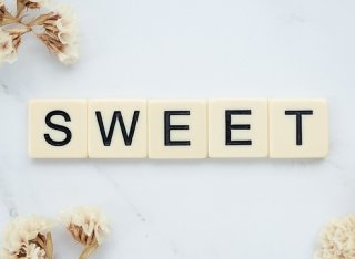 SWEET spelled out in scrabble letters on white floral background - copyright Pixabay