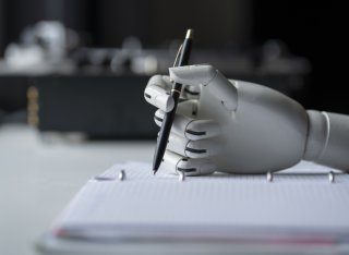 artificial robotic arm write down some notes with pen