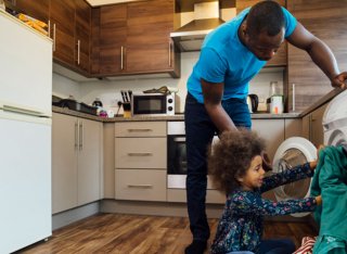 Father and young son loading the washing machine