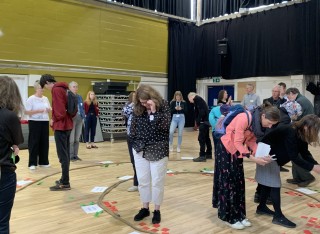 People engaging in a workshop activity and looking at post-it notes on the ground