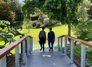 Students walking over the bridge by the lake, Stag Hill campus