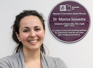 A photograph of Monica Saavedra with her purple plaque