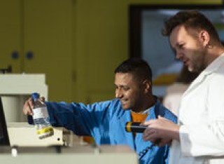 Two students in lab coats working in a laboratory
