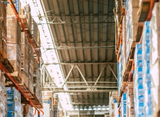 Interior of Amazon warehouse with two members of staff wearing safety helmets