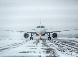 Airliner on an airport runway in a blizzard