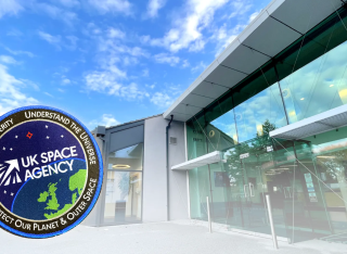 A mostly glass building with a stamp of the UK Space Agency