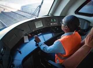woman in orange hi vis jacket driving train