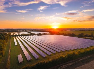 Solar panels on a farm field at sunset 