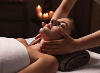 A woman at a spa receiving a neck massage