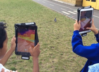 Children holding up digital pads with thermal imaging