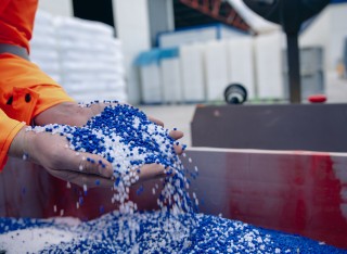 Plastic granules are poured from the hand 