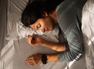 woman sleeping peacefully in bed with a smartwatch on her wrist