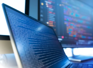 Laptop and monitor showing coding