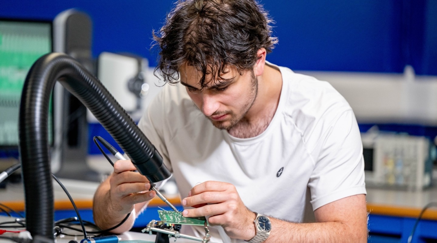 A student is working on a breadboard in Surrey's Electrical and Electronic Engineering lab
