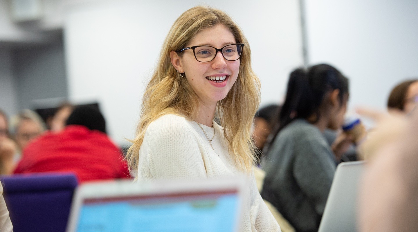 A psychology student smiles during a class discussion.