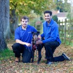 two male students walking a dog