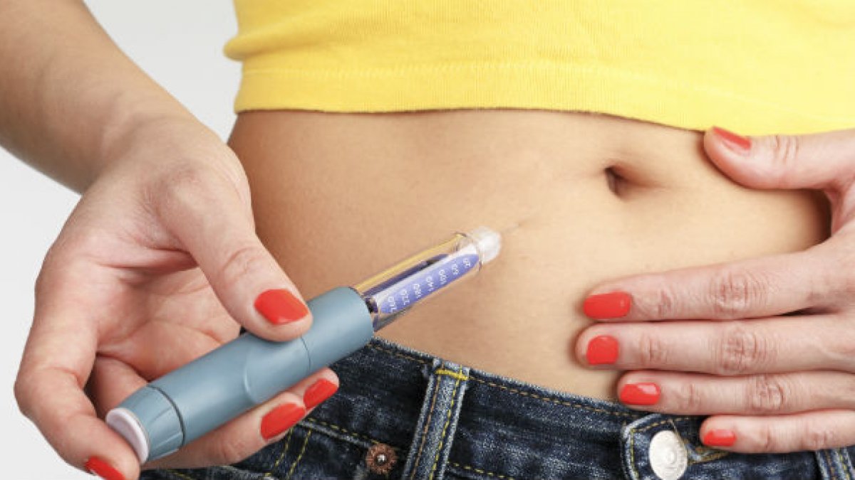 Lady injecting herself with diabetes medication