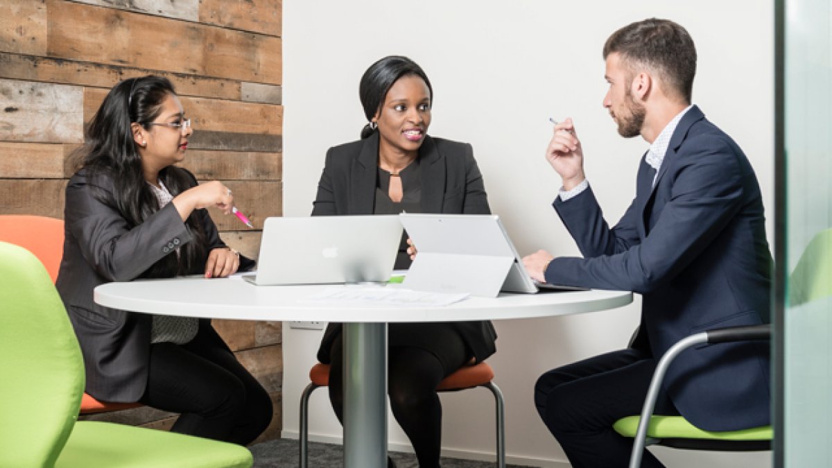 Three people sitting around a table