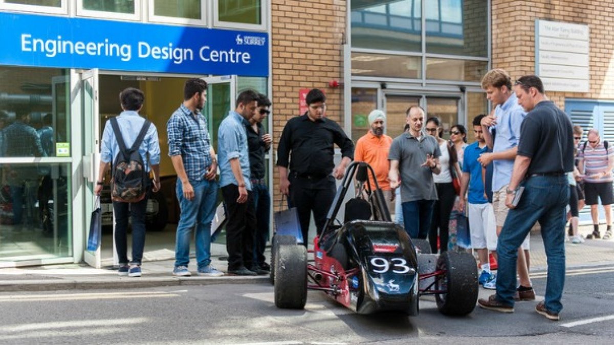 Students looking at Formula Student racing car