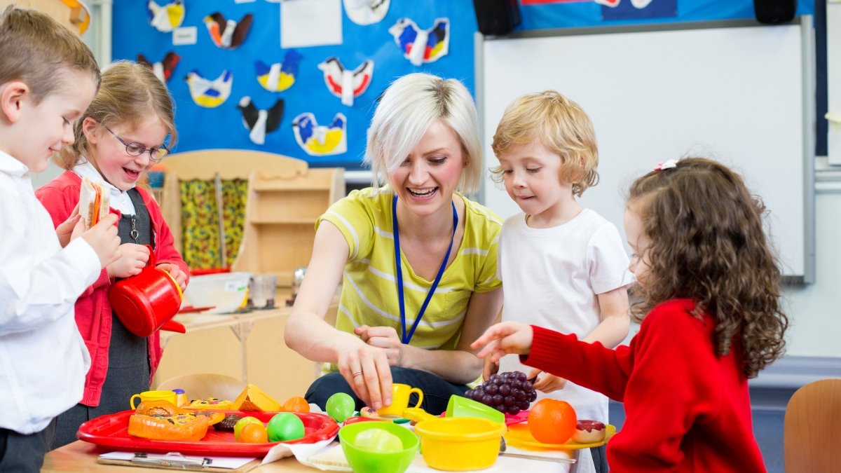 Children in a nursery with an adult teaching them