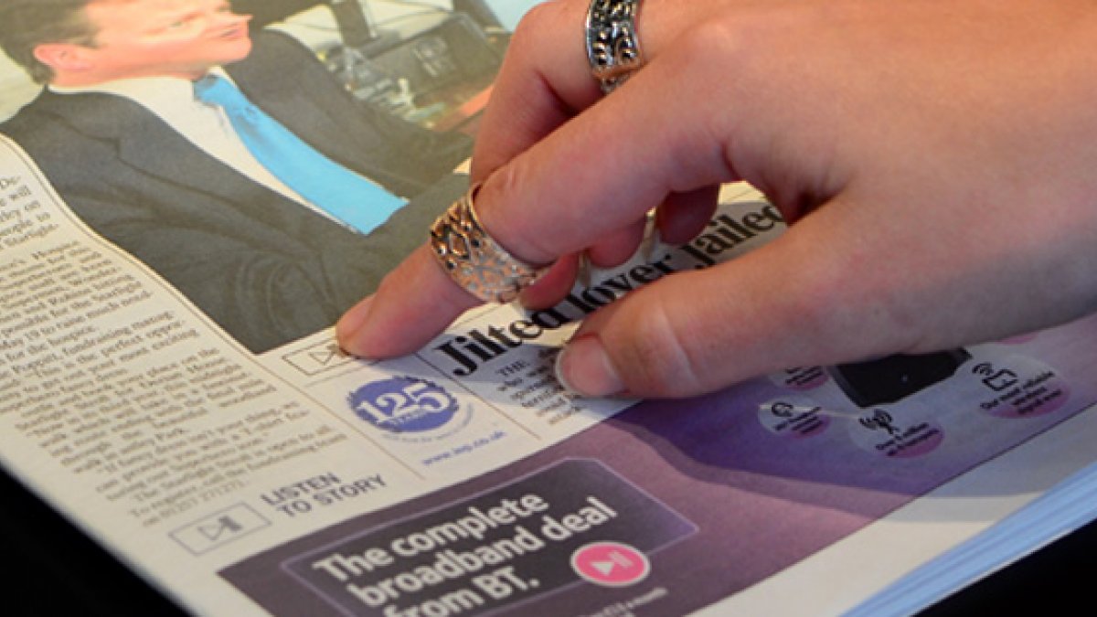 Finger pointing at newspaper