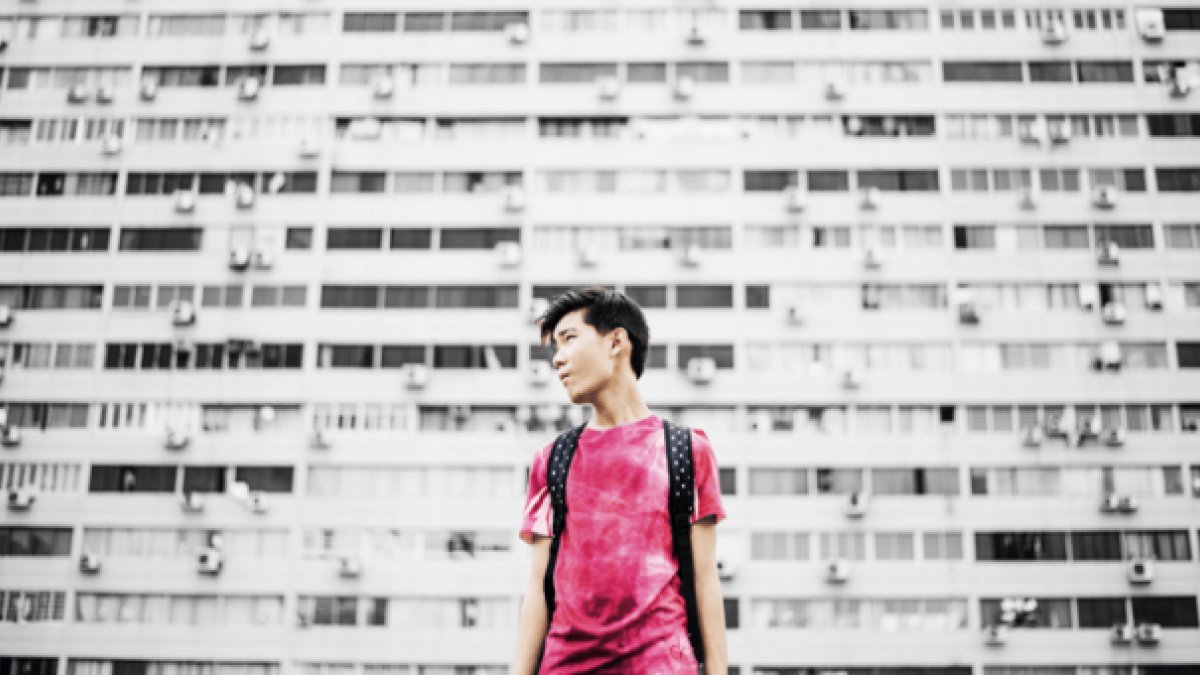 young person standing against wall