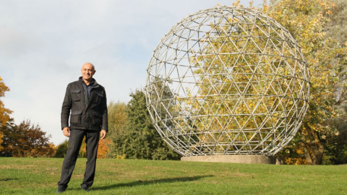 Jim Al Khalili stood next to Surrey University globe sculpture