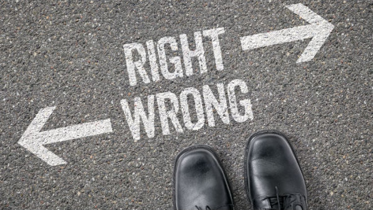 Two feet standing over writing saying "RIGHT" and "WRONG" on the ground