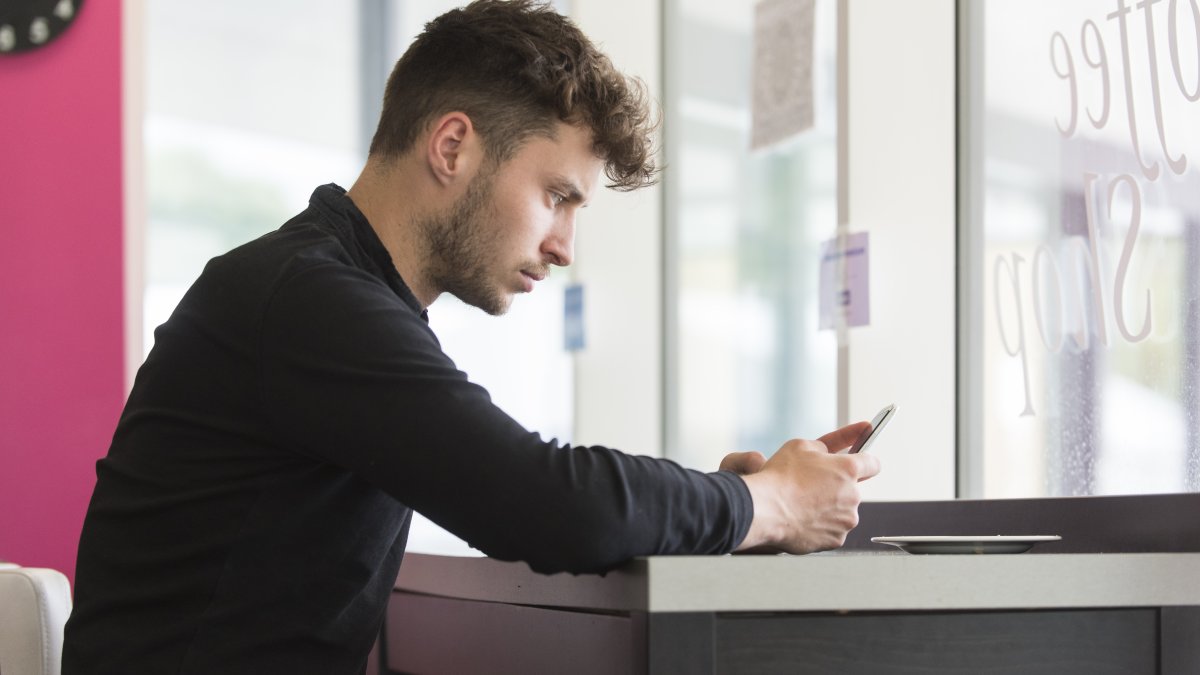 Man sitting down looking at his phone.