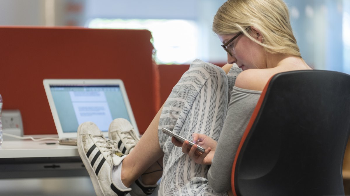 Student in library on her mobile phone