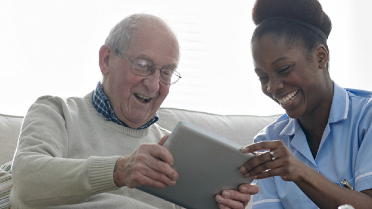 Nurse and man sat on a sofa