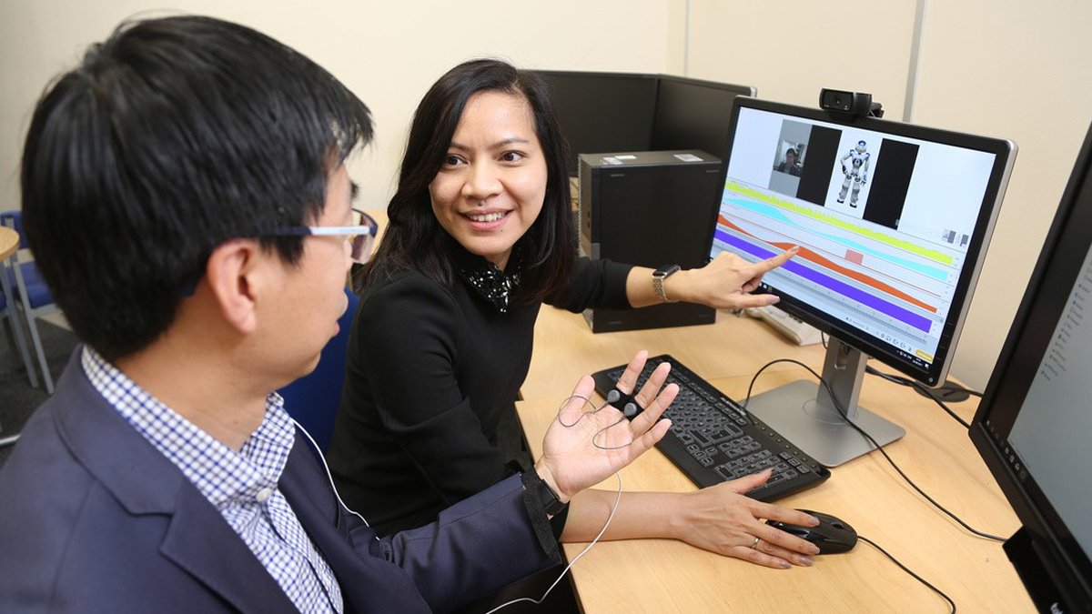 Male and female member of staff sitting by computer