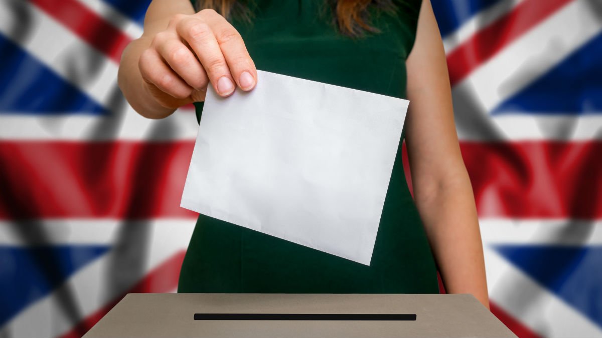 An anonymous woman posts her voting form into a UK ballot box
