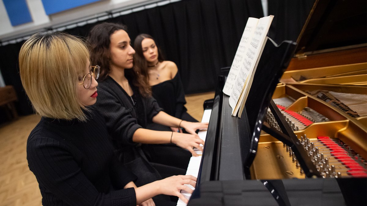 Female students playing the piano