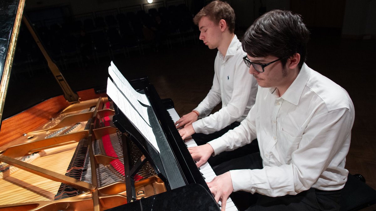 Male students playing the piano