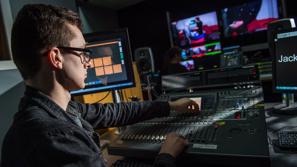 Male student using editing equipment