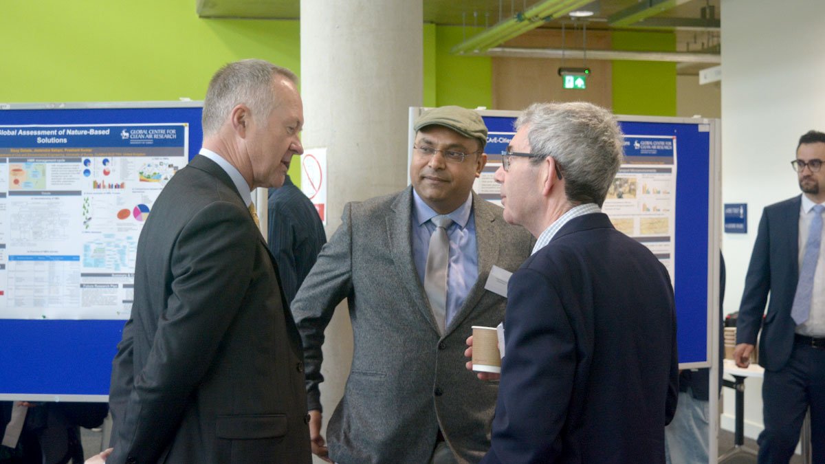 Prashant Kumar speaking with two men at workshop