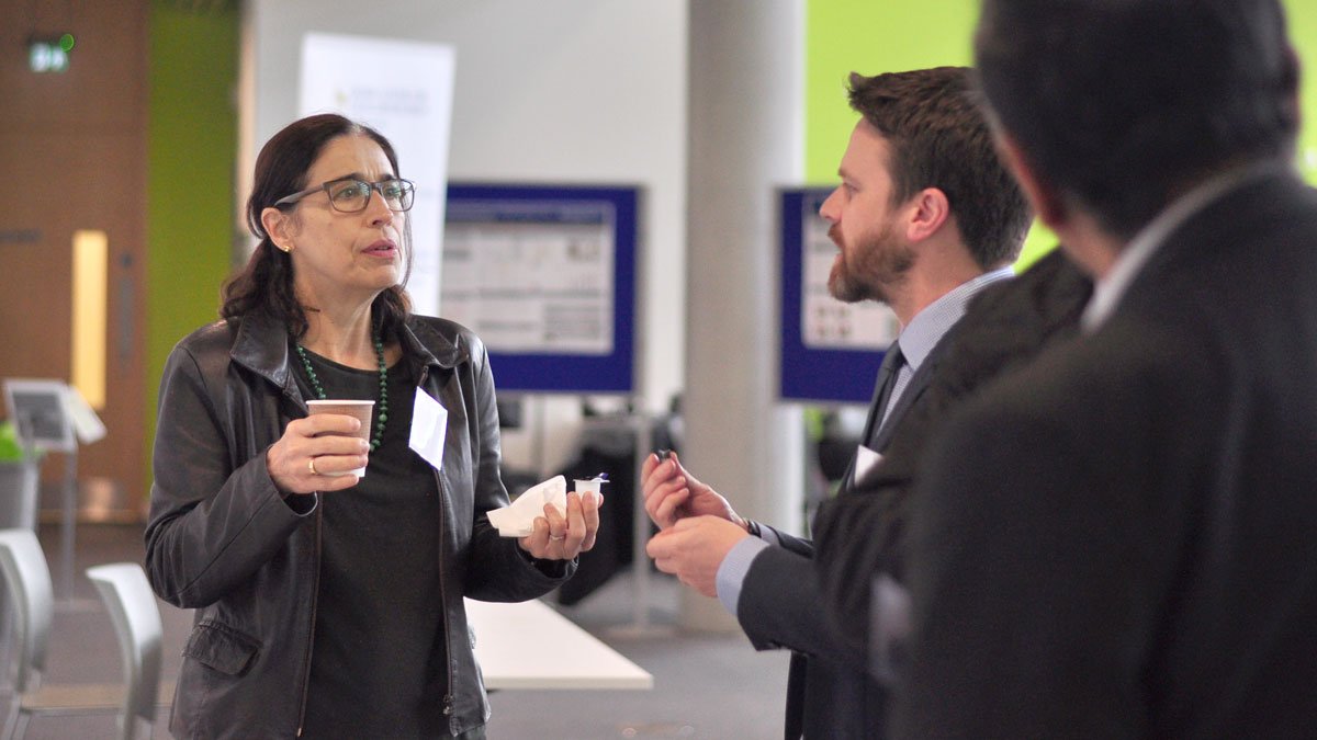 Woman speaking to two men