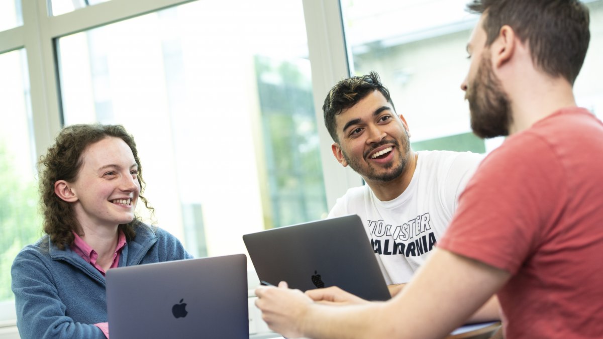 Students talking over laptops