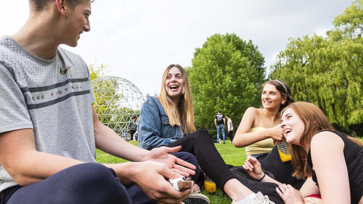 Students sat on grass at Free Fest