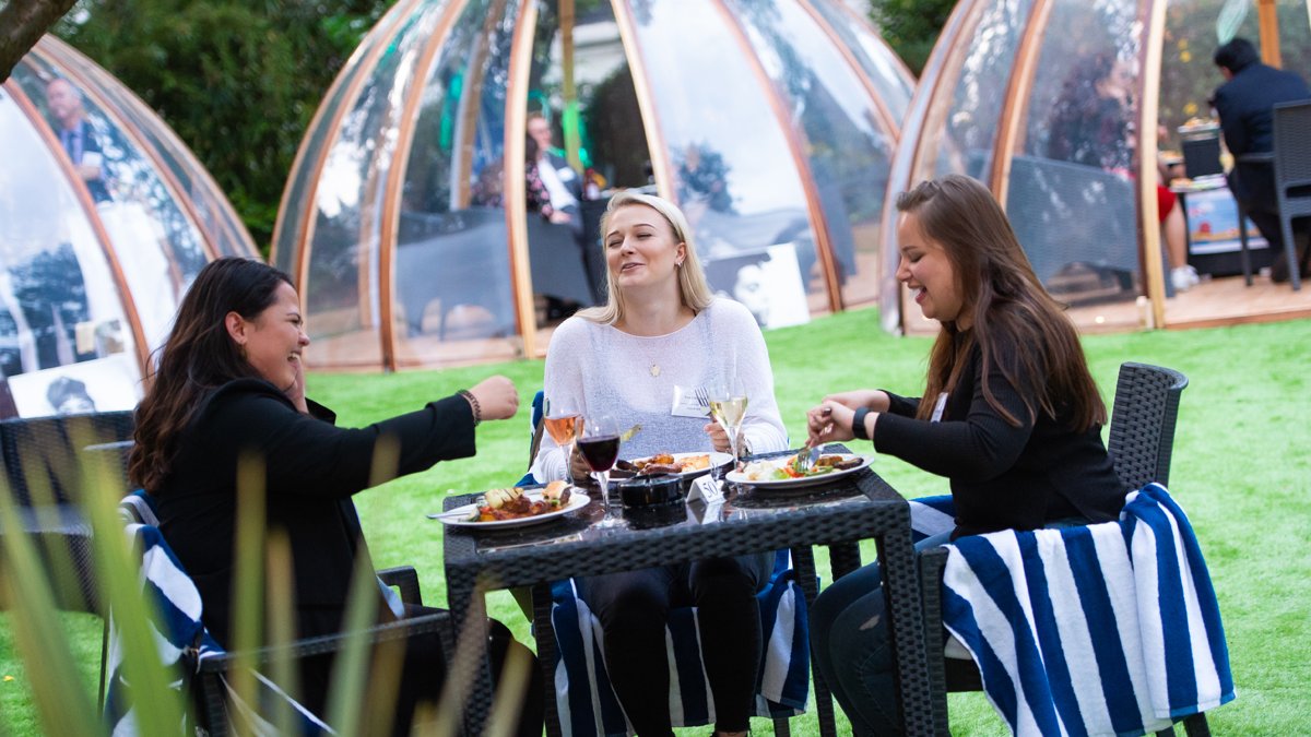 A group of people outside smiling at a reception.