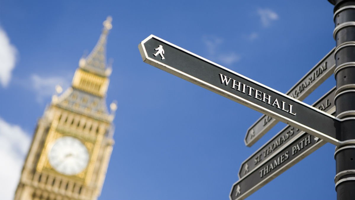 A tourist sign pointing towards Whitehall with Big Ben in the background