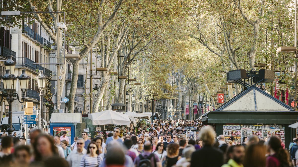 Las Ramblas in Barcelona with busy crowds walking down the street