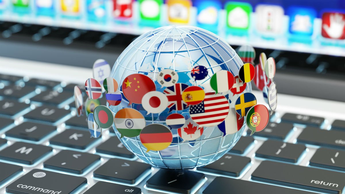 A techy global floats on a keyboard with international flags circling it