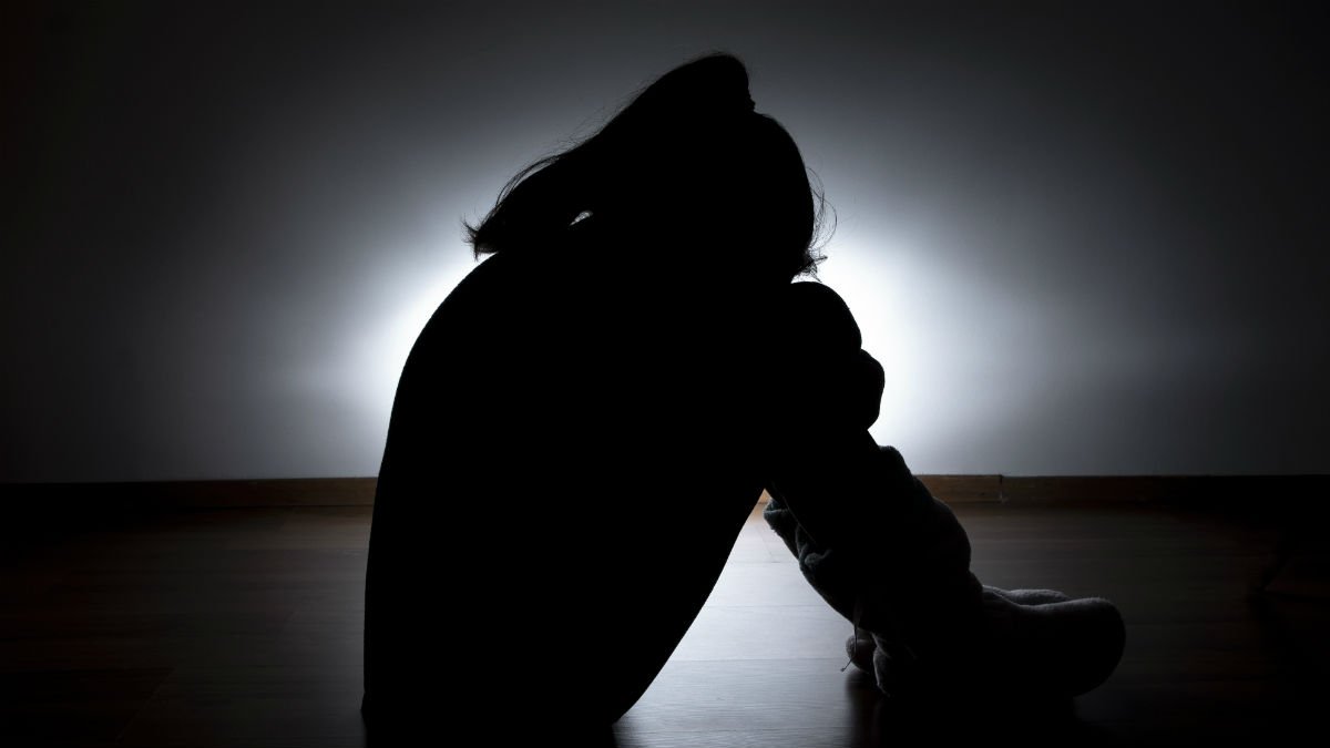 Child sat wrapping arms around their legs
