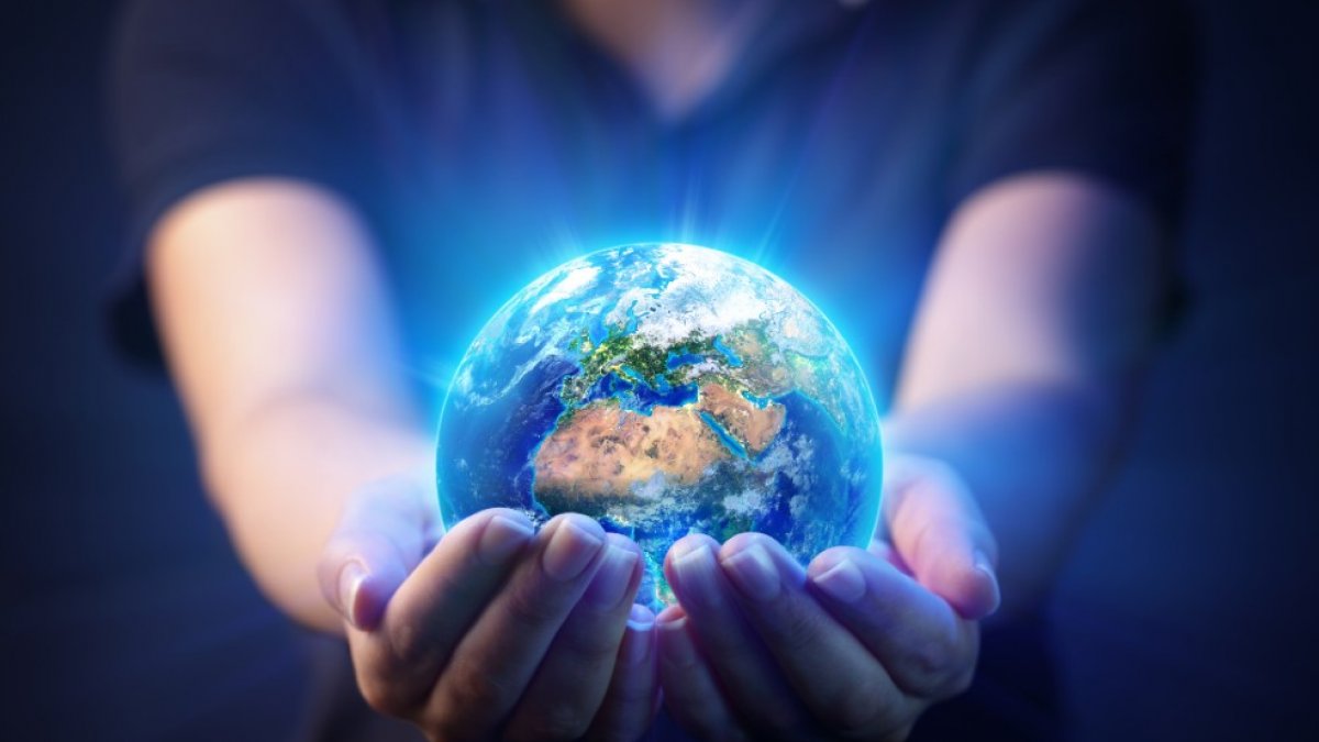 A person holds a shining globe in their hands